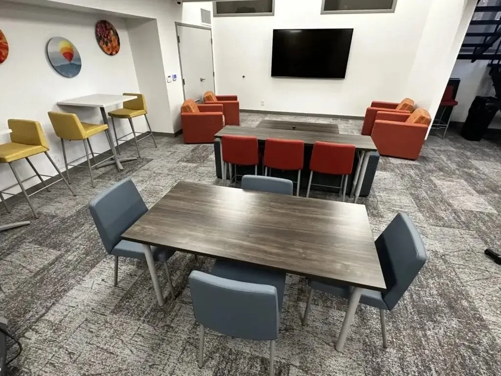 A common room at Leora with tables, chairs and armchairs